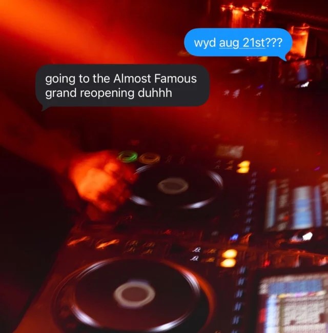 CDJs and mixer glowing under red light in the centered DJ booth at Almost Famous